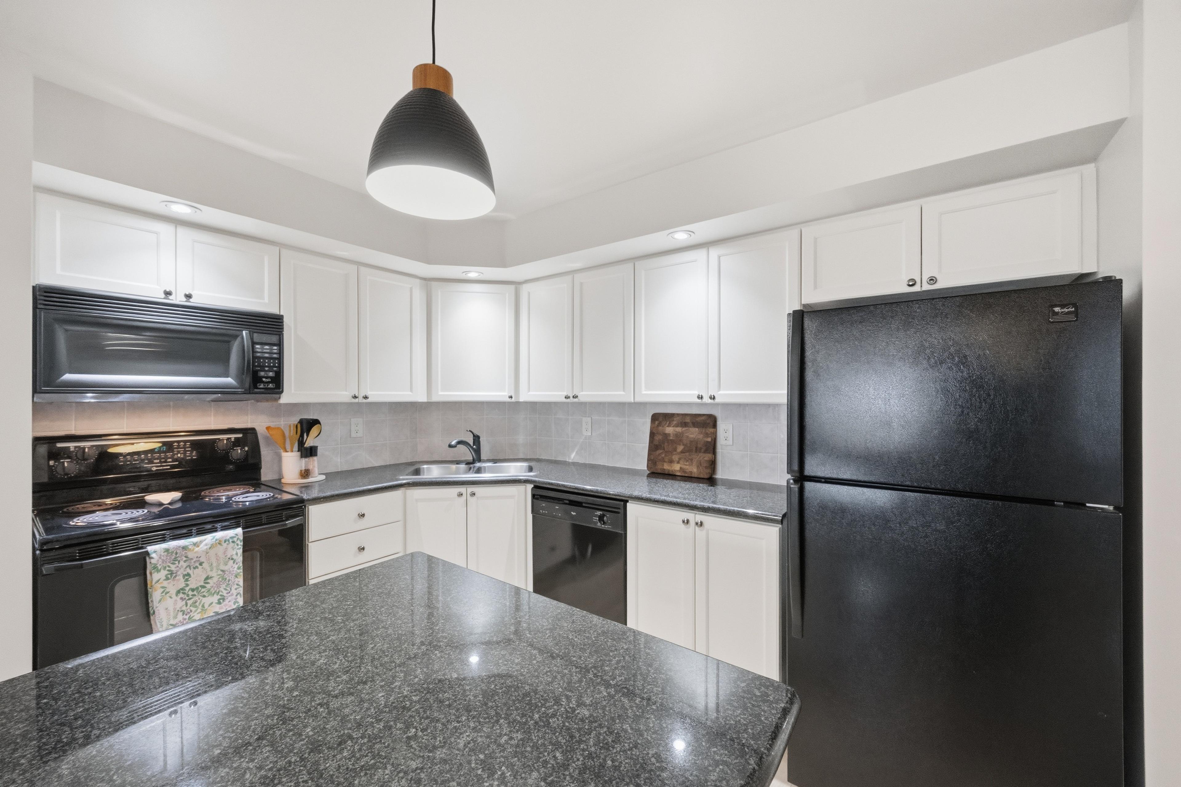 Granite kitchen peninsula with pendant lighting