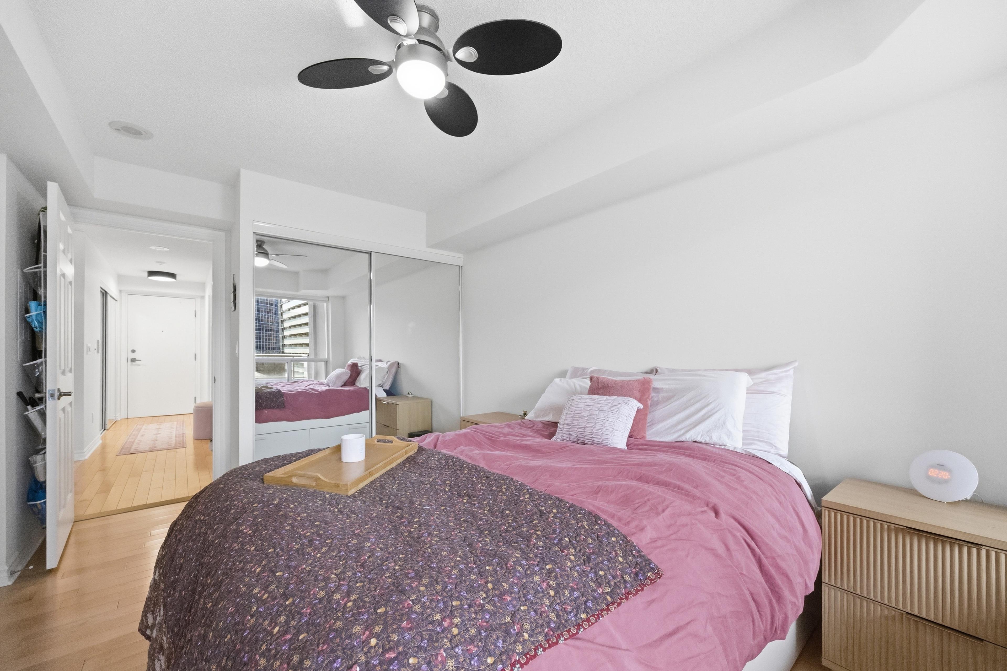Primary bedroom with mirrored closet and hallway view
