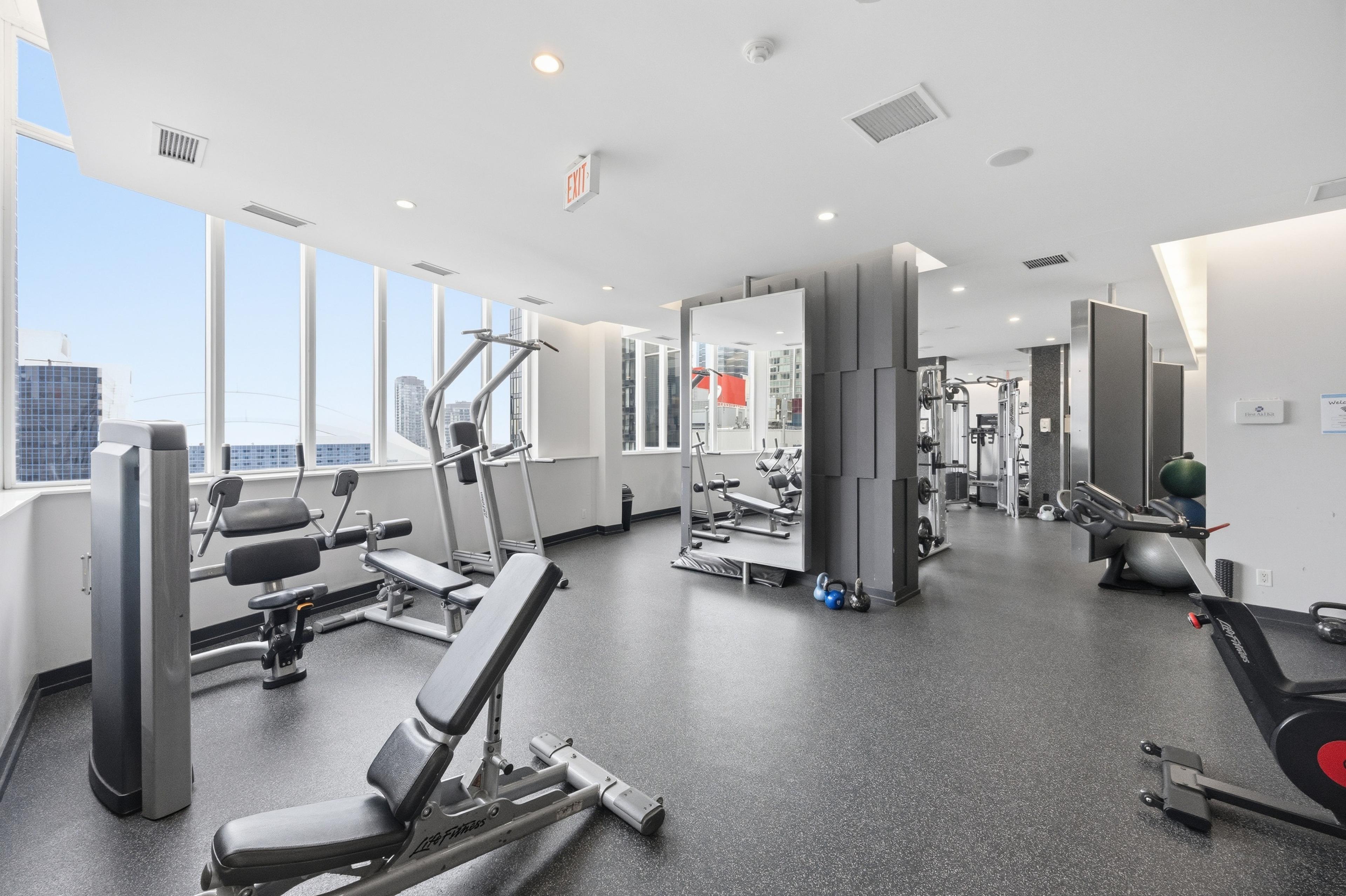 Building gym with floor-to-ceiling windows and full equipment