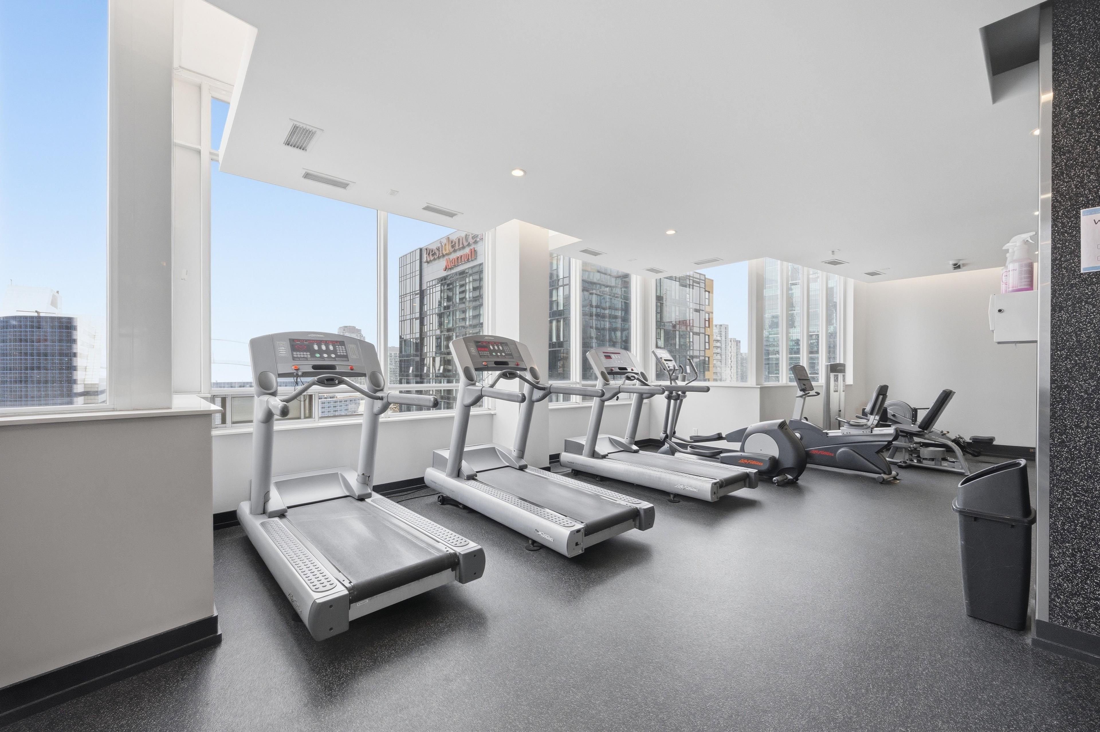 Gym cardio area with treadmills and city views