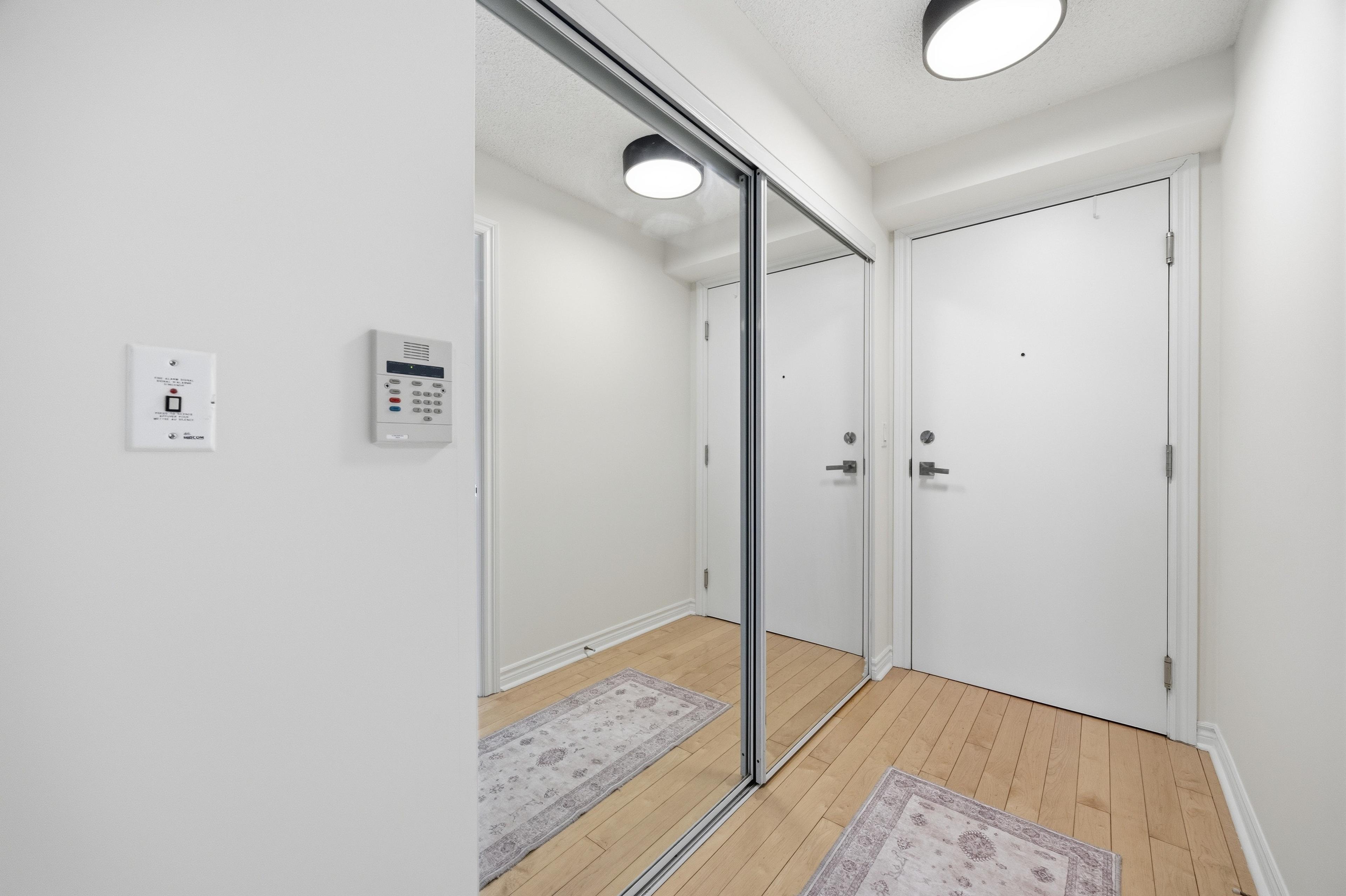 Entryway with intercom panel and mirrored storage