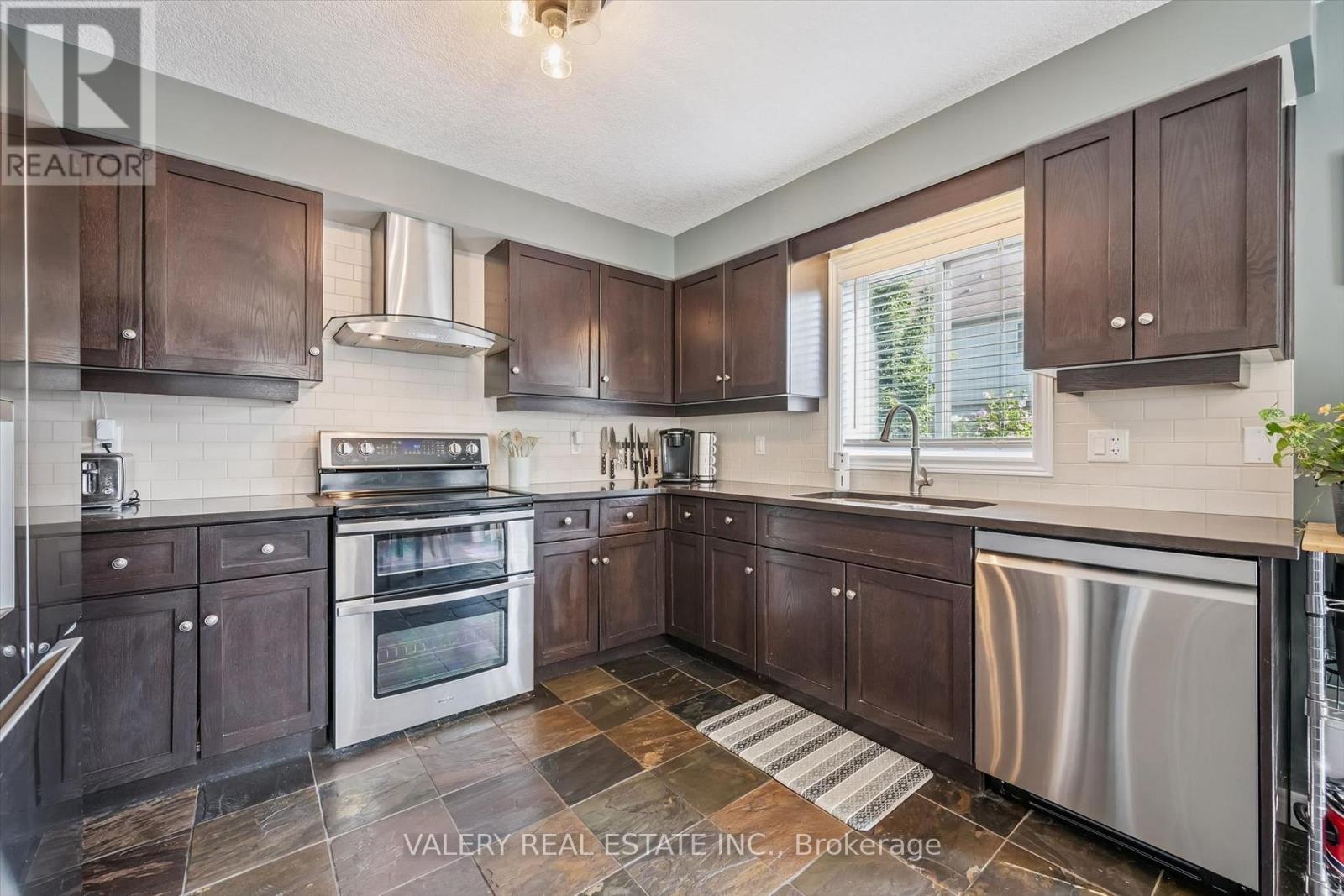 Kitchen with dark cabinetry and stainless steel appliances