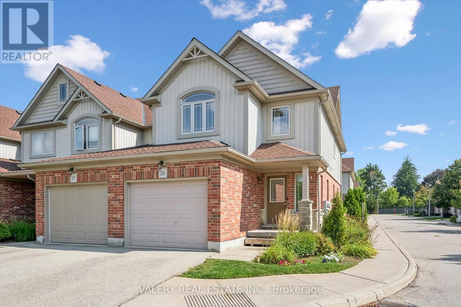 Front exterior — brick-and-siding end-unit townhome with double garage