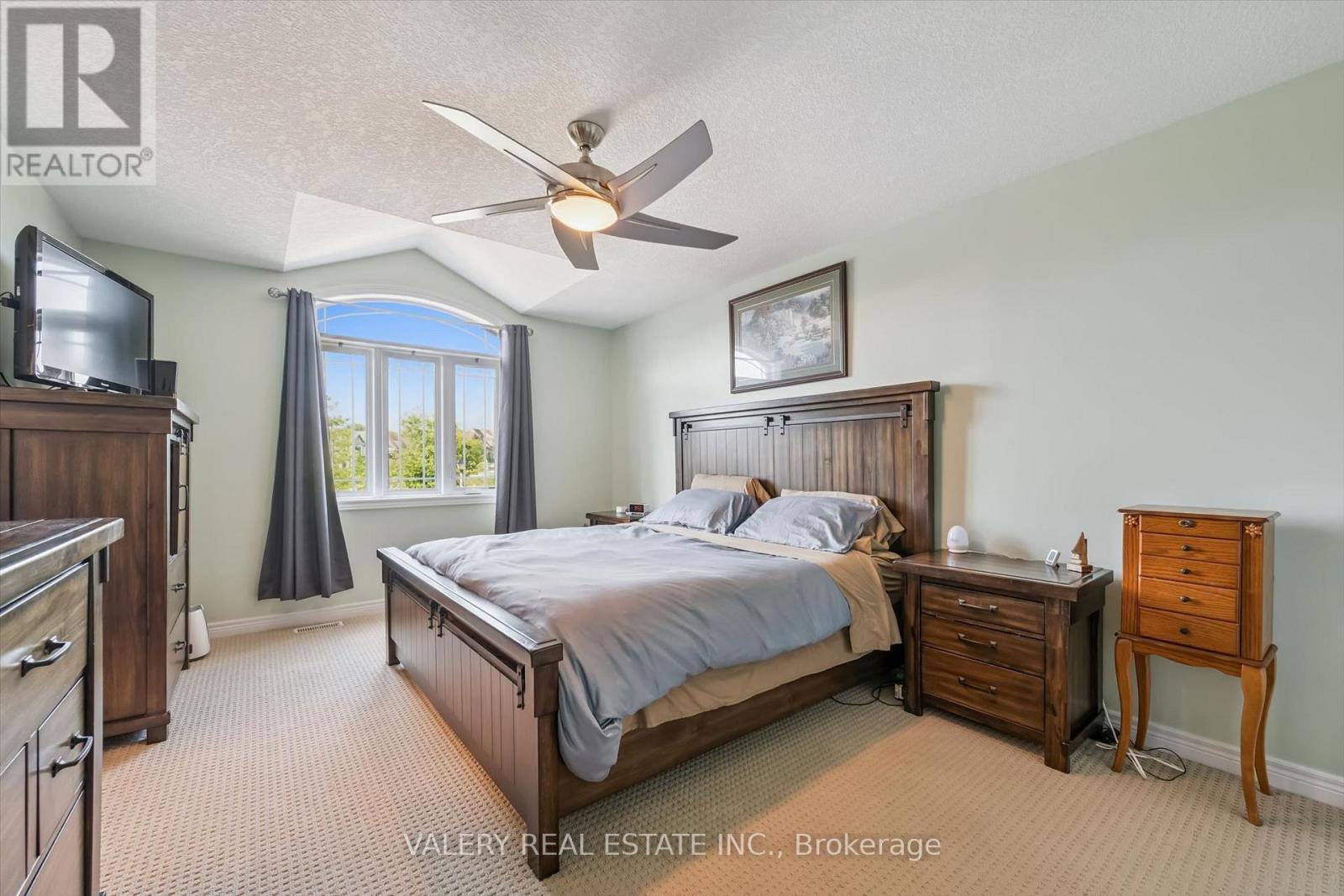 Primary bedroom with vaulted ceiling and ceiling fan