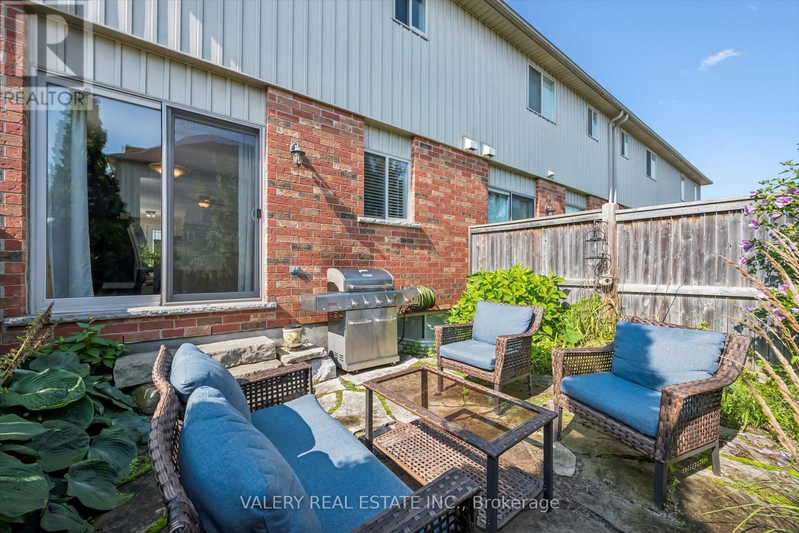 Fenced rear yard with patio seating and gas BBQ